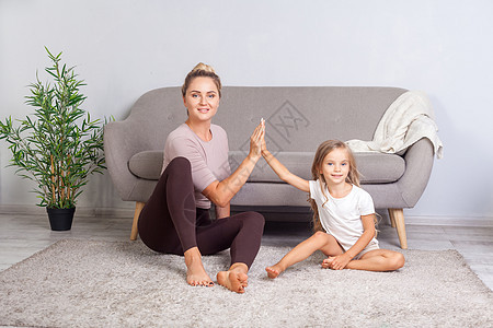 母亲和女儿一起运动 在家玩得开心的游戏卫生童年健康瑜伽女士娱乐沙发保健身体家庭图片