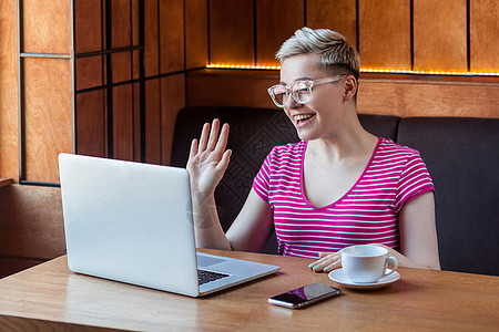 担任办公室职务和工作的有情感的年轻女性技术衬衫微笑眼镜工人笔记本电脑手势商务短发图片