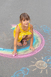 孩子在沥青上画彩虹 有选择的焦点想像力婴儿乐趣教育活动操场插图横幅绘画染色图片