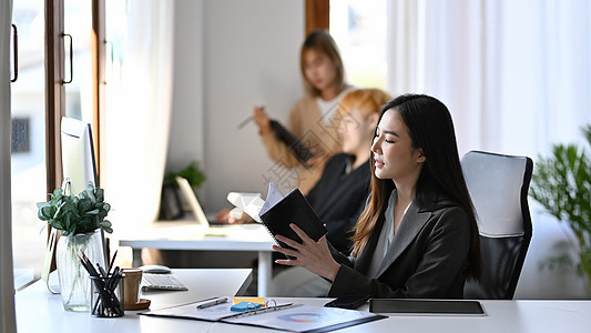 深思熟虑的女商务人士 在她的笔记本上读到信息图片