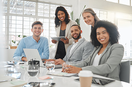 一群不同的商务人士在工作时在一张桌子上开会 商务人士在办公室使用技术进行交谈和规划 一起工作的同事图片