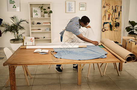 看织品的非裔美国人的设计师 年轻时装设计师检查材料卷 裁缝检查他的纺织品 在他的设计工作室工作的创意企业家图片