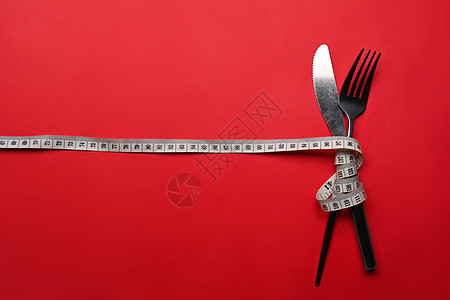刀叉和叉子 上面有红色背景的计量胶带 复制文字空间 健康生活方式概念图片