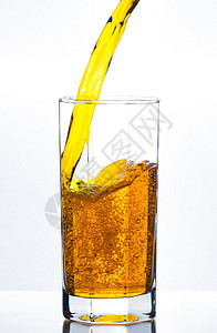 将橙汁倒在玻璃杯上图片