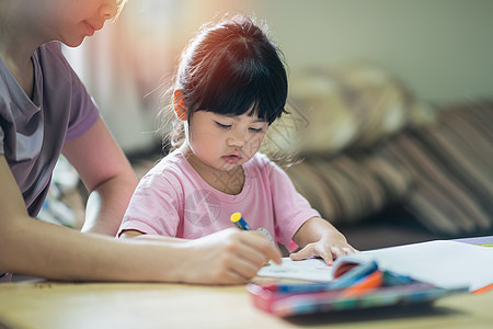 可爱的小孩用五颜六色的颜料绘画 亚洲女孩和她的母亲使用蜡笔画颜色 婴儿艺术家活动生活方式概念女性乐趣专注房间孩子蜡笔父母画笔妈妈图片