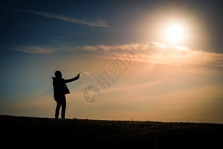 黄昏时站在山丘上的男人的休眠材料爬坡背景阴影美景天空三鹰日落公园例子图片