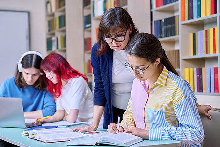 青少年学生群体和在图书馆书桌上的师范学习老师男生中学女士团体电脑考试女性知识智力图片