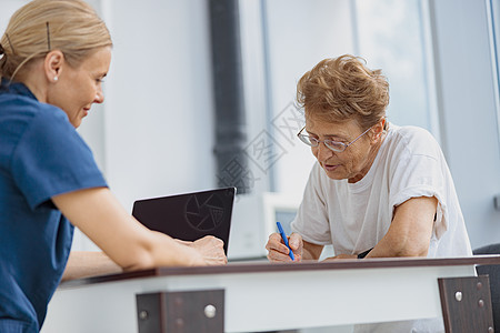 女性患者在与诊所医生预约时填满保险法律文件 并在门诊部的医生预约文档处方协议治疗帮助护士病人签名合同疾病图片