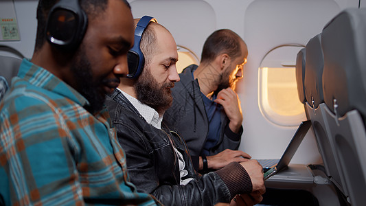 飞机飞行期间 企业家在智能手机上浏览互联网图片