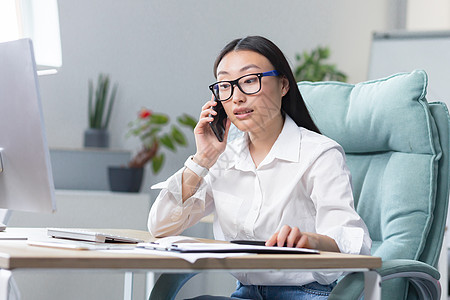 在现代办公室工作的成功女商务人士 亚洲女性打电话 女工穿白衬衫女士顾问施工人士企业家桌子电脑技术职场呼唤图片