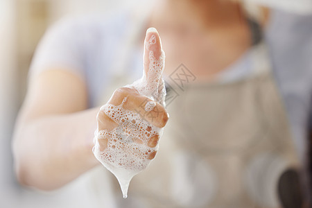 一名身份不明的妇女洗手 提倡健康习惯和日常护理 她的手指被涂上泡沫 用双手露出大拇指举起手势图片