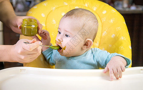 小宝宝在吃花椰菜 有选择的专注点孩子食谱饮食早餐勺子桌子椅子快乐微笑横幅图片