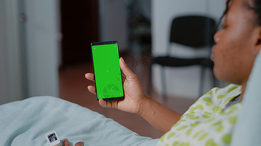 患者用绿色屏幕拿着智能手机的近距离关机卫生房间女士治疗电话疾病住院色度诊断管子图片