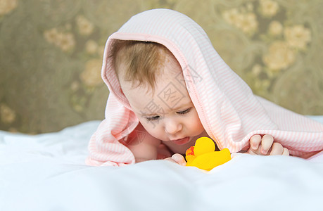 在毛巾里洗完澡的婴儿 有选择地集中注意力微笑女孩皮肤情感童年孩子喜悦快乐生活横幅图片