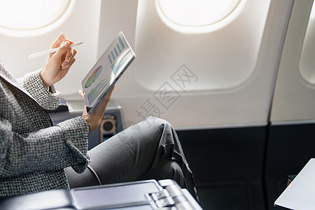 一位成功的亚洲女商务人士或女企业家在飞机上穿着正式西装 坐在商务舱的座位上 在飞行期间使用平板电脑女士航班工作客机女性商务套装课图片
