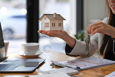房地产经纪人手里拿着房子模型和房子钥匙 抵押房地产投资和保险概念办公室住宅项目客户文档建筑合同销售财产贷款图片