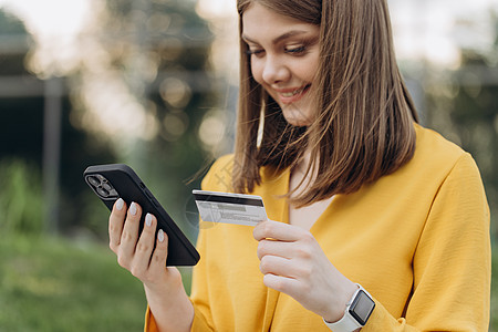 年轻女性在线支付 使用银行服务 输入信息 购物 在网上商店订购 进行安全支付 特写拿着信用卡和智能手机的女性手图片