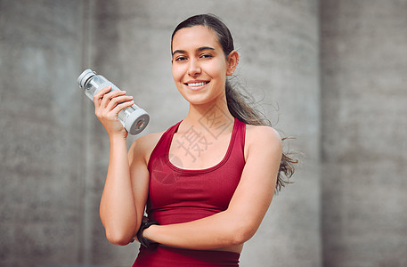 记得你的水吧 一个年轻女运动员在户外跑动时喝的饮用水被剪裁成肖像图片