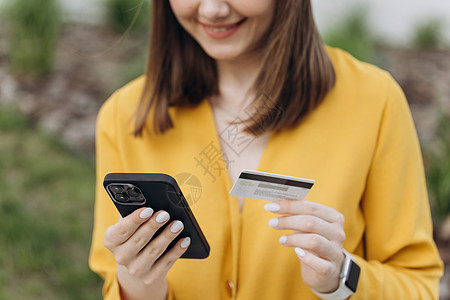 特写了拿着信用卡和智能手机的女性手 年轻女性在线支付 使用银行服务 输入信息 购物 在网上商店订购 进行安全支付图片