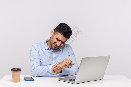 坐在办公室和工作着的情感男人风湿员工手腕职场创伤扭伤伤害手臂商业电脑图片