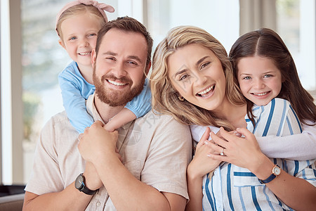 一个开朗的年轻白人家庭在家里拥抱和结合的肖像 两个微笑的父母带着他们的女儿在家里放松 年轻的父母带着孩子在家图片