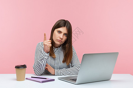 有情感的年轻女性 坐在办公室工作 有粉红色背景手指手势沙发电脑注意力老师职场危险女士警报图片