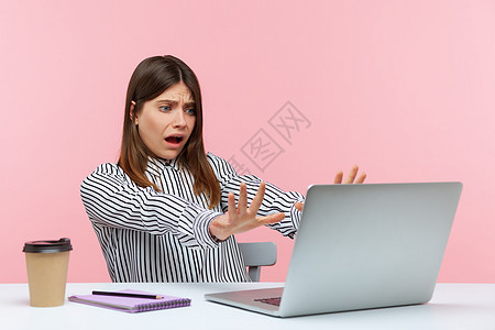 有情感的年轻女性 坐在办公室工作 有粉红色背景黑发懦夫震惊女士电脑压力焦虑悲伤商业危险图片