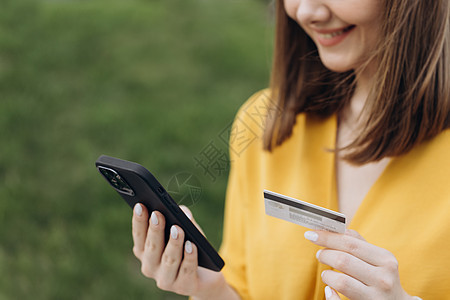 在线支付女性手持信用卡并使用智能手机进行在线购物风险监视器银行业支付安全零售商业卡片店铺交换图片