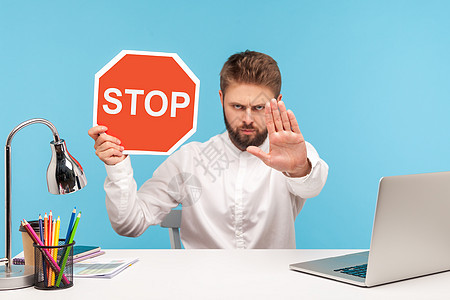 情感商务人士在蓝背景的笔记本电脑上工作控制手势安全蓝色办公室商业人士工人禁令胡子图片