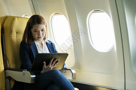 女商务人士在飞机上 在笔记本电脑上工作管理人员航空公司商业飞行理念女士运输技术机场乘客图片