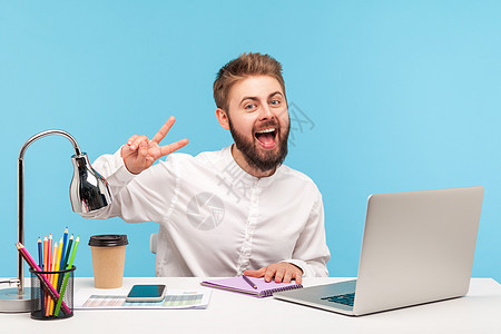 情感商务人士在蓝背景的笔记本电脑上工作男人成人成功人士胡子幸福微笑胜利事项商务图片