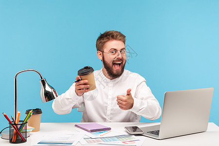 情感商务人士在蓝背景的笔记本电脑上工作职场情绪商务微笑幸福战略男人工人办公室快乐图片
