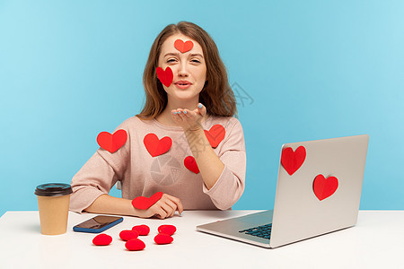 情感年轻女性在蓝背景的笔记本电脑上工作员工幸福情怀贴纸商业互联网微笑乐趣商务人士图片