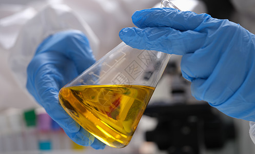 手绘科学家拿着实验室玻璃器皿与金油液体在化学实验室图片