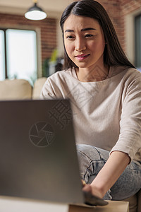 家庭办公室的亚洲妇女自由职业者互联网技术学生人士沙发桌子房子女孩商务图片