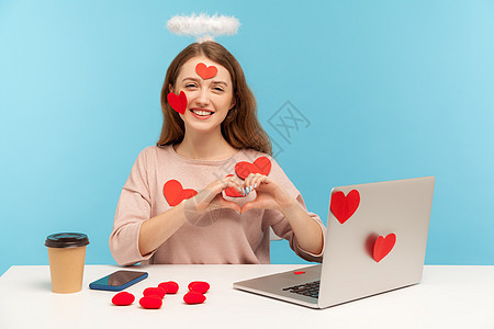 情感年轻女性在蓝背景的笔记本电脑上工作员工商务机构情怀贴纸职业幸福光环互联网女孩图片