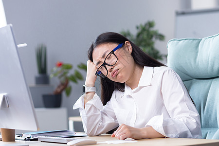 一位悲伤的亚洲女商务人士对自己的能力感到绝望 情绪低落 在办公室的电脑前工作人士失业企业家施工疲劳标志破产头痛技术挫折图片