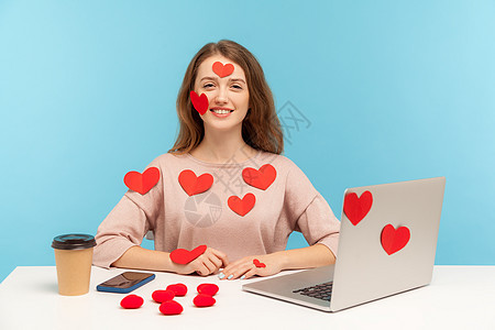 情感年轻女性在蓝背景的笔记本电脑上工作机构女孩商业员工贴纸庆典乐趣网站商务情怀图片