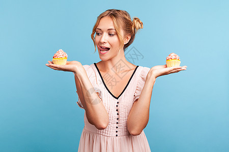 青蓝背景的年轻情感女性饮食乐趣糖果食物裙子面包味道发髻节食甜点图片