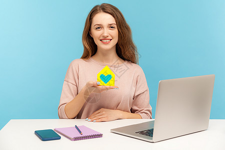 情感年轻女性在蓝背景的笔记本电脑上工作代理人经理销售女孩商业职场机构商务人士保险图片