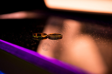 两枚结婚戒指放在镜子表面的近视镜上金子仪式宏观礼物反射庆典紫色婚姻珠宝新娘图片