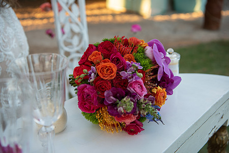 白桌上红玫瑰和兰花的新娘花束图片