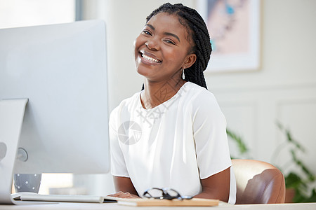笑容能给任何人带来光明的一天 一个年轻的非洲女商务人士在电脑上工作的镜头图片