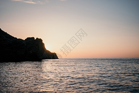 红色的日落在海面上 岩石火山悬崖 抽象自然 夏季或春季海洋背景 笑声季节阳光旅行蓝色海滩辉光晴天调子运动太阳图片