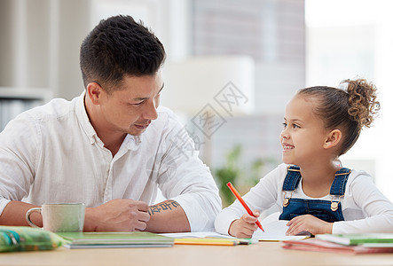 爸爸是最好的老师 一个年幼的父亲 在家帮女儿做功课时帮助他的女儿图片