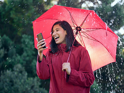 好消息是 一个女人带着雨伞走出去时使用她的手机 (笑声)图片