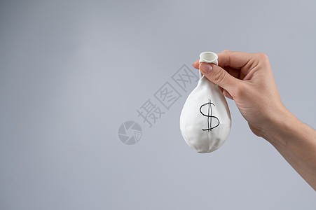 一个女人拿着一个带有美元标志的减缩气球 货币价值膨胀的概念 笑声流动碰撞生长投资价格气泡失败银行业市场储蓄图片