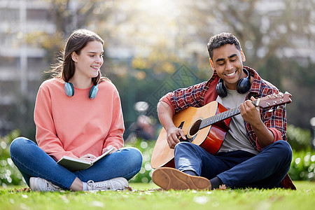 一位年轻男女在大学的学习课间休息时弹吉他 (笑声) 这首歌是献给我爱人的图片