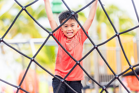 亚裔儿童笑着玩攀爬户外游乐场闲暇校园幼儿园活动婴儿金发院子蹦床绳索喜悦图片