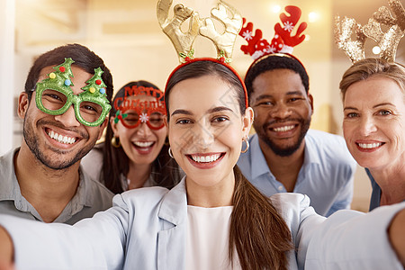 传播节日的欢乐气氛 一群商务人士在工作的圣诞派对上自拍的肖像图片